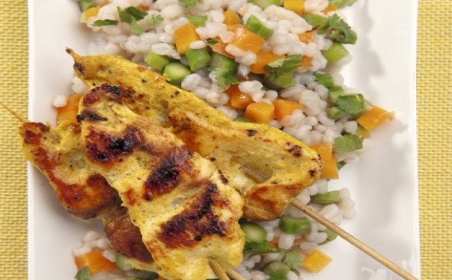 Brochetas de pollo al curry con pilaf de cebada.